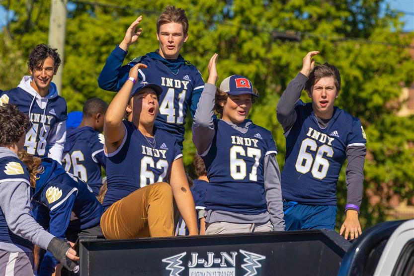 Students ride on a homecoming parade float